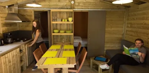 Intérieur du cottage Anjou avec table, chaises et coin repas