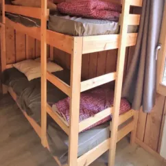 Lits superposés dans le chalet PMR, avec draps et couvertures.