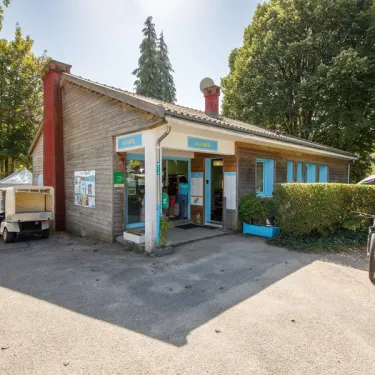 Office du camping en bois avec entrée et vélos garés au Camping Paradis Les 2 Îles