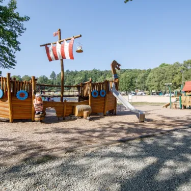 Bateau en bois avec toboggan pour enfants au Camping Paradis Les 2 Îles