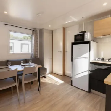 Salle à manger et cuisine dans l'MH Confort + 2CH – 4P au Camping Paradis Les 2 Îles