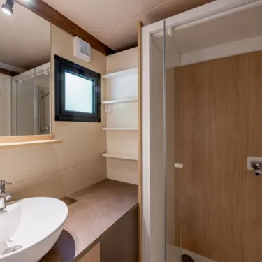 Salle de bain avec lavabo, douche et étagères - Cottage Premium - Camping Paradis Les 2 Îles
