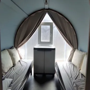 Camping Le Savoy - Intérieur de tente avec deux lits et armoire