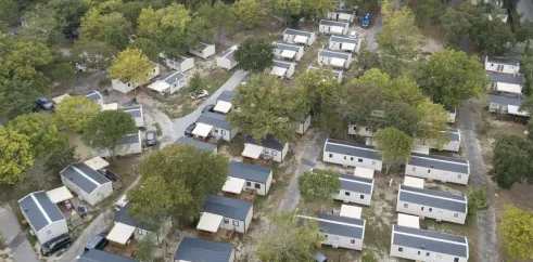 Vue aérienne du camping Paradis Albret avec des mobil-homes alignés entre les arbres.