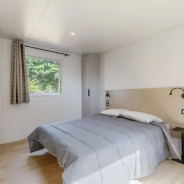 Chambre avec lit double et vue sur les arbres, MH Confort+ PMR 2CH – 4P, Camping Paradis Albret