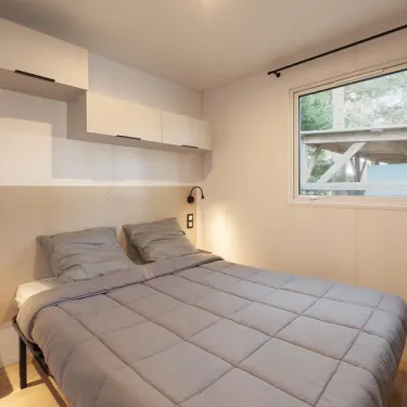MH Confort+ 3CH – 6P - Camping Paradis Albret : chambre avec lit et rangements