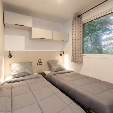 MH Confort+ 3CH – 6P - Camping Paradis Albret, chambre avec deux lits et placard mural