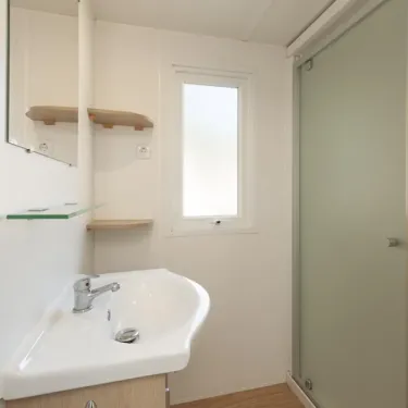 Salle de bain avec lavabo et douche dans MH Classique 2P - Camping Paradis Albret