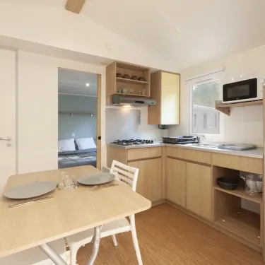 MH Classique 2P - Camping Paradis Albret : cuisine avec table et placard
