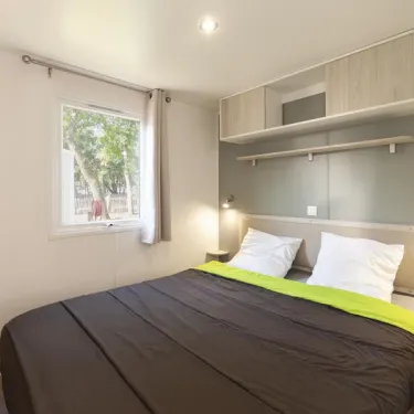 Chambre du mobil-home MH Premium 2CH – 4P - Camping Paradis Albret, lit double et rangement