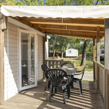 MH Premium 2CH – 4P - Camping Paradis Albret : véranda avec table et chaises