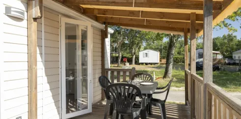 MH Premium 2CH – 4P - Camping Paradis Albret : véranda avec table et chaises