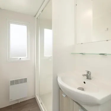 Salle de bain avec lavabo, douche et radiateur - MH Premium 4CH - Camping Paradis Albret
