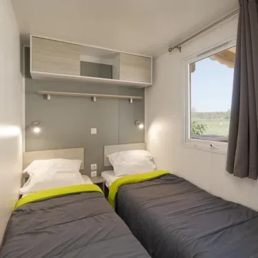 Chambre avec deux lits, rangements et vue sur le jardin - MH Premium 4CH - Camping Paradis Albret