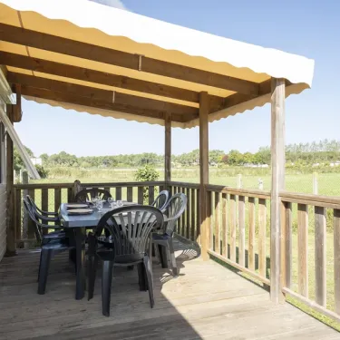 MH Premium 4CH – 8P - Camping Paradis Albret : terrasse en bois avec table et chaises