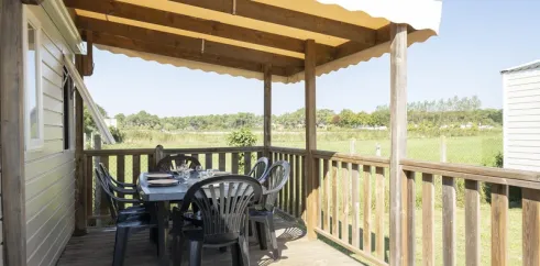 MH Premium 4CH – 8P - Camping Paradis Albret : terrasse en bois avec table et chaises