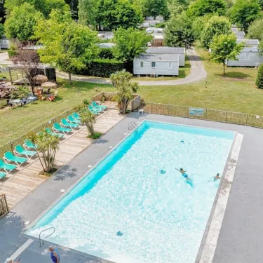 Camping La Clairière avec une piscine et des chaises longues.
