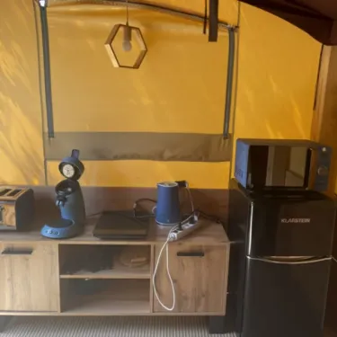 Tente Baroudeur 1 Chambre 2 Personnes Sans Sanitaires - Paradis Family des Issoux : cuisine compacte avec réfrigérateur, micro-ondes et cafetière