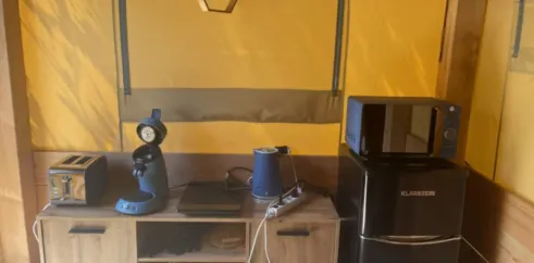 Tente Baroudeur 1 Chambre 2 Personnes Sans Sanitaires - Paradis Family des Issoux : cuisine compacte avec réfrigérateur, micro-ondes et cafetière