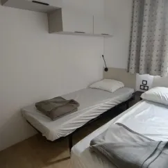 Chambre avec deux lits simples et rangements murals - MH Confort+ 2Ch - 4P (Sam) - Camping Paradis la Baie de Ploemeur