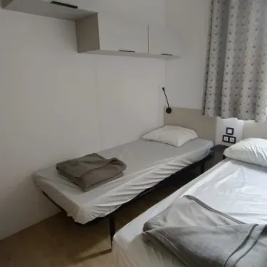 Chambre avec deux lits simples et rangements murals - MH Confort+ 2Ch - 4P (Sam) - Camping Paradis la Baie de Ploemeur