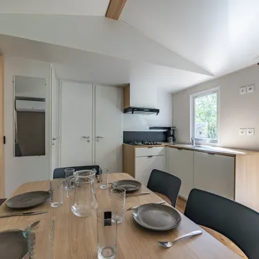 MH Confort 3CH – 6P - Camping Paradis la Baie de Ploemeur : salle à manger avec table et cuisine