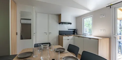 MH Confort 3CH – 6P - Camping Paradis la Baie de Ploemeur : salle à manger avec table et cuisine