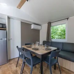 MH Confort 3CH – 6P - Camping Paradis la Baie de Ploemeur : salle à manger avec table et canapé
