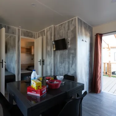 MH Premium 3CH – 6P (Sam) - Camping Paradis la Baie de Ploemeur : salle à manger avec table et chaises