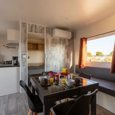 MH Premium 3CH – 6P (Sam) - Camping Paradis la Baie de Ploemeur : cuisine ouverte avec table à manger