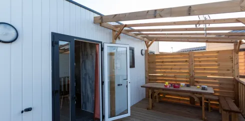 MH Premium 3CH – 6P (Sam) - Camping Paradis la Baie de Ploemeur : terrasse avec table en bois et pergola