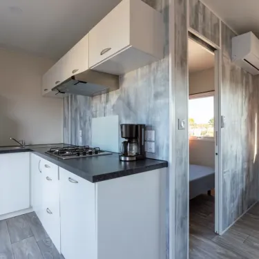 Cuisine moderne avec plaques, four et café machine dans le mobile home MH Premium 3CH – 6P (Sam) - Camping Paradis la Baie de Ploemeur
