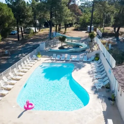 Piscine avec toboggan et chaises longues au Camping La Pinède en Provence