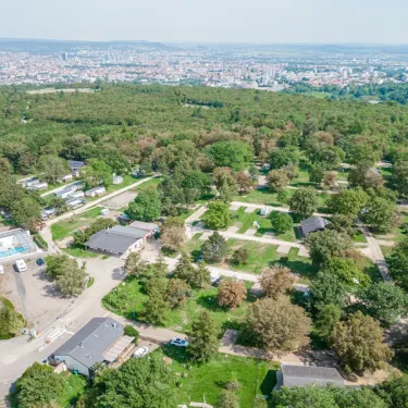Vue aérienne du camping avec mobil-homes, arbres et piscine visible