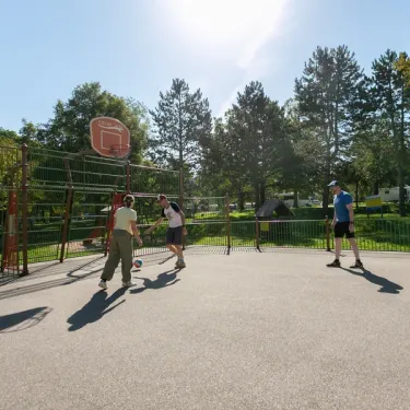 Camping Bel Air Village le Brabois : enfants jouent au basket-ball dans un parc