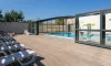 Piscine couverte avec chaises longues en bois au Camping Bel Air Village le Brabois