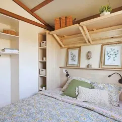 Chambre cottage avec lit double et étagères dans Cottage Premium 3CH – 6P - Camping Bel Air Village Le Brabois