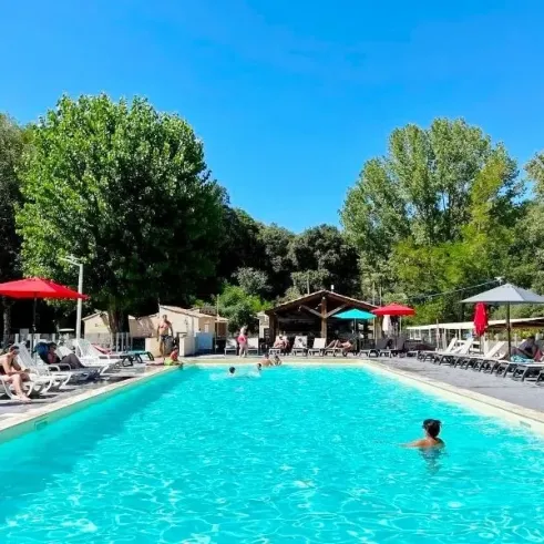 Piscine extérieure avec chaises longues au Camping La Berge Fleurie