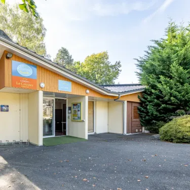 Entrée du Camping Paradis Le Coiroux avec bâtiment d'accueil.