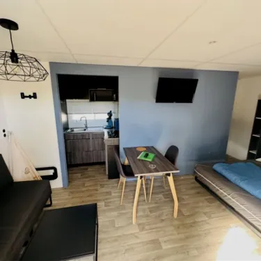 Intérieur Mobil Home Luxe Studio Jacuzzi - Paradis Family les Rives de l'Hérault, cuisine, table, lit et télévision