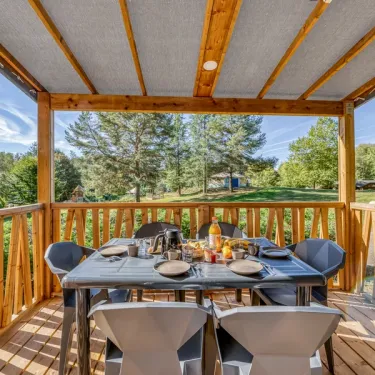 Cottage Premium 2CH – 4P - Camping Paradis Le Coiroux, véranda avec table pour 6 personnes