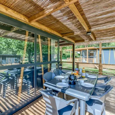 Cottage Premium 2CH – 5P (SAM) - Camping Paradis Le Coiroux, véranda avec table et chaises
