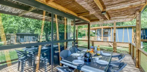 Cottage Premium 2CH – 5P (SAM) - Camping Paradis Le Coiroux, véranda avec table et chaises