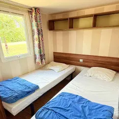 Mobil Home Family 4 Chambres 8 Personnes Clim TV - Paradis Family les Rives de l'Hérault : chambre avec 2 lits simples et rideaux colorés