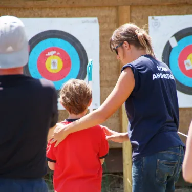 Camping Les Viviers : enfant avec adulte devant cible d'archerie
