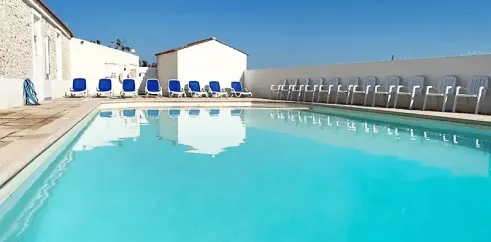Piscine avec chaises longues bleues au Camping Le Pavillon Bleu