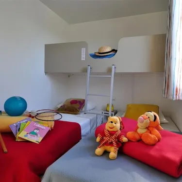 Mobil Home Aloha 2 Chambres 4 Personnes - Camping La Touesse : chambre avec lits superposés et peluches
