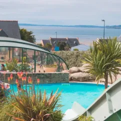 Camping Paradis - La Mer d'Iroise : piscine avec toboggan et vue sur la mer