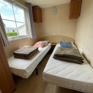 Mobil Home Moorea 2 Chambres 4 Personnes - Camping La Touesse : deux lits simples, literie, rangements