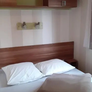 Mobil Home Ophéa 2 Chambres 4 Personnes Terrasse Semi-couverte - Camping La Touesse, lit double avec tête de lit en bois